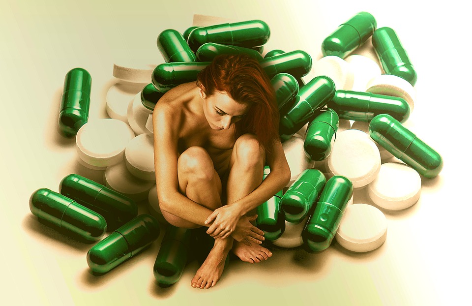Skinny woman siting a lot of pill